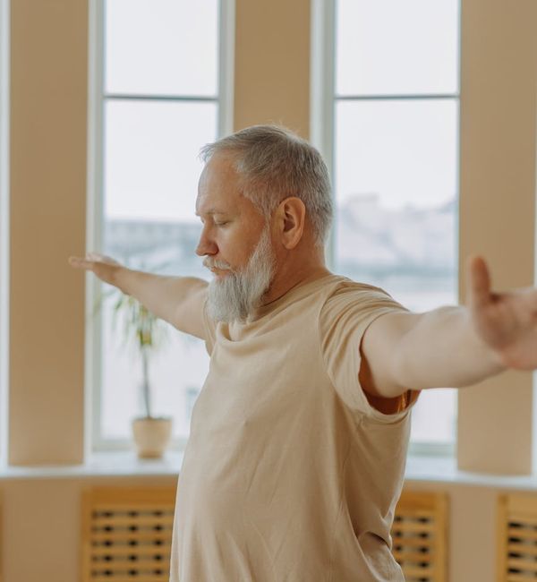 Person stretching gently by a window at sunrise.